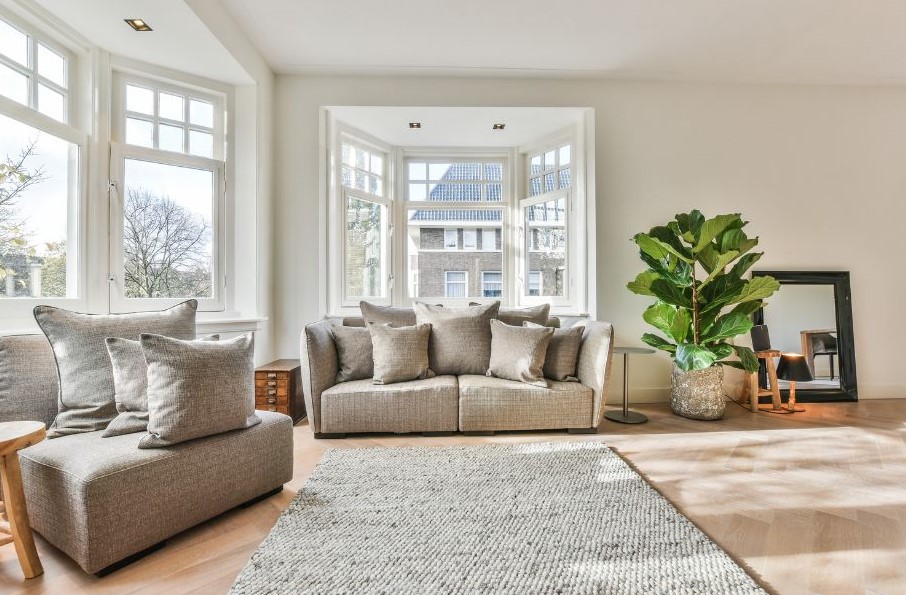 Pebbled wool rug, neutral living room, natural light, big windows, comfy sofas, plant & mirror, wooden floor